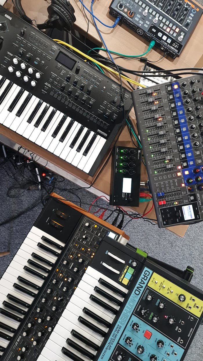 Top view of electronic music equipment including synthesizers and a mixer for studio recording.